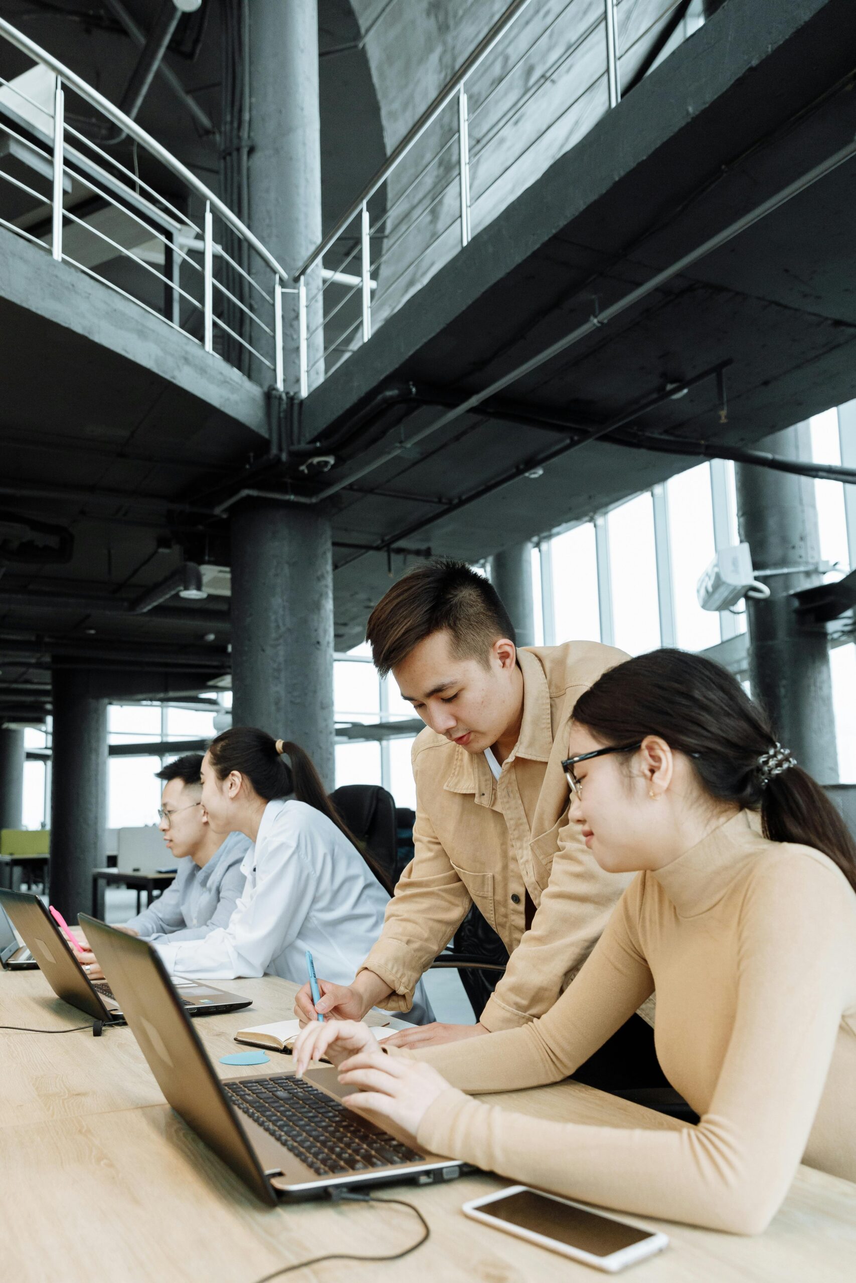 Colleagues working together on laptops in a contemporary office environment.