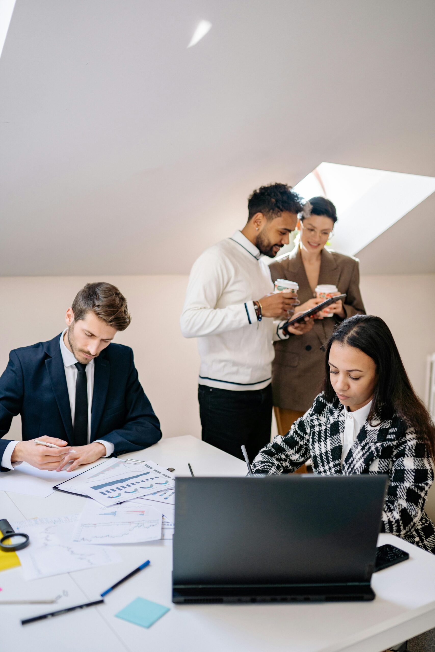 A group of professionals engaged in teamwork inside a bright office setting.